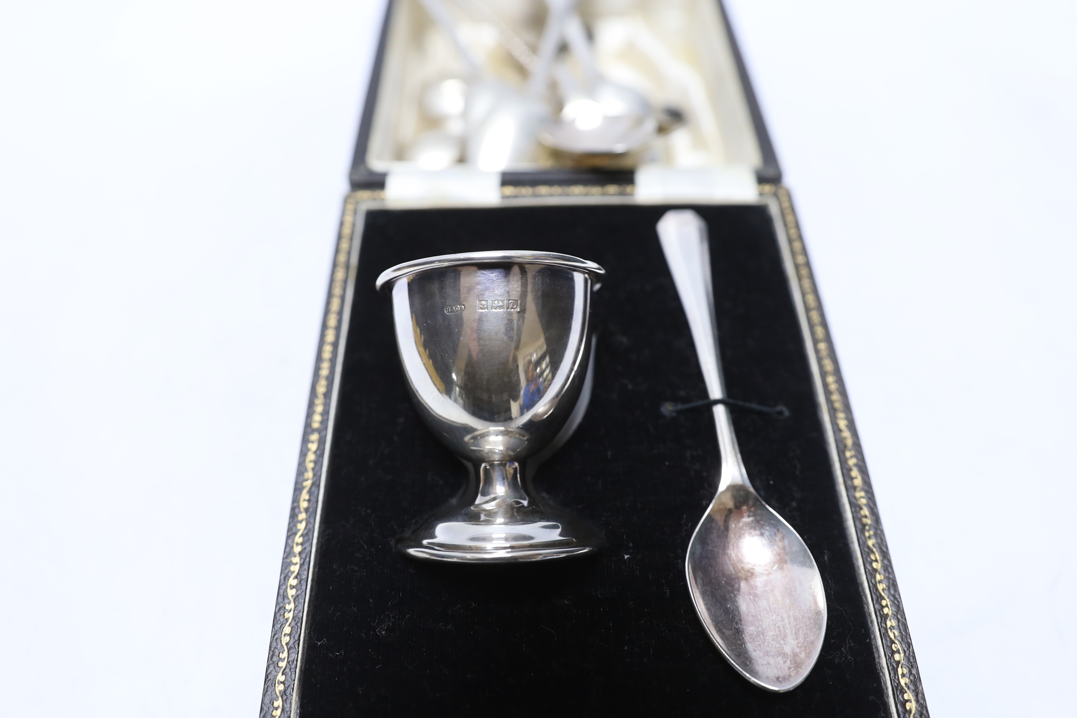 A cased silver egg cup, spoon and other assorted silver flatware.